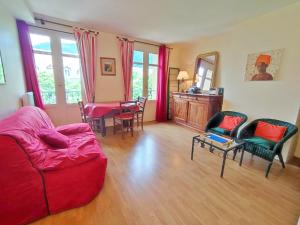salon z czerwoną kanapą i krzesłami w obiekcie T2 cosy centre ville w mieście Luchon