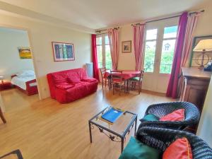 salon z czerwoną kanapą i stołem w obiekcie T2 cosy centre ville w mieście Luchon