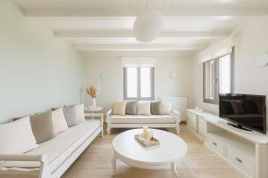 Stone Pearl Kea في Elliniká: غرفة معيشة بأثاث أبيض وتلفزيون