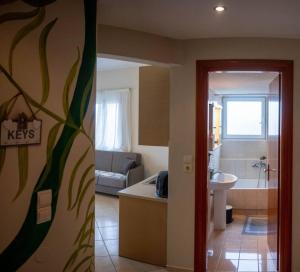 a room with a bathroom with a tub and a sink at Πράσινη πινελιά διαμέρισμα in Kissamos