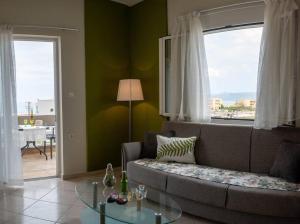 uma sala de estar com um sofá e uma mesa de vidro em Πράσινη πινελιά διαμέρισμα em Kissamos