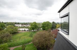 uma vista para um parque a partir de uma janela de uma casa em Apartment Forty Staines Upon Thames - Free Parking - Heathrow - Thorpe Park em Staines
