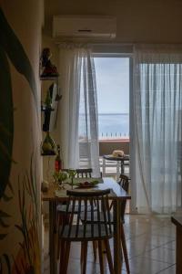 uma cozinha com mesa e cadeiras com vista para o oceano em Πράσινη πινελιά διαμέρισμα em Kissamos