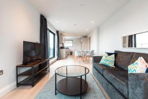 uma sala de estar com um sofá e uma mesa em Apartment Forty Staines Upon Thames - Free Parking - Heathrow - Thorpe Park em Staines