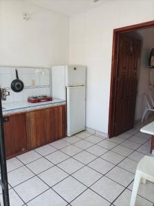 uma cozinha com um frigorífico e piso em azulejo em Hotel Villa Tulipanes em Zihuatanejo