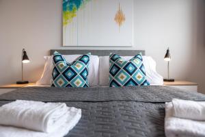 a bedroom with a large bed with pillows on it at Apartment Forty Staines Upon Thames - Free Parking - Heathrow - Thorpe Park in Staines