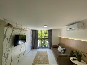 Uma TV ou centro de entretenimento em Flat Beira-Mar Luxo - 113 Unity by Jess