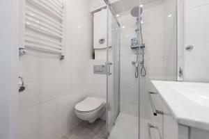 Baño blanco con aseo y lavamanos en JK Apartment Przytulny Katowice Ligota en Katowice