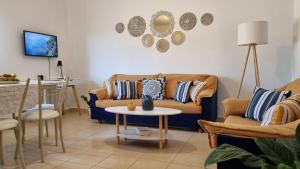 een woonkamer met een bank en een tafel bij Cypress Garden House in Ayía Marína