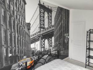 a bedroom with a view of the brooklyn bridge at La petite trapue in Desvres