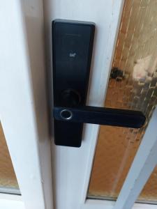 a black door handle on a door with a window at Venos rooms in Hirtshals