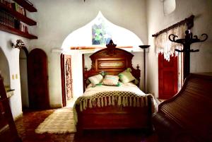 - une chambre avec un lit dans une pièce dotée d'une fenêtre cintrée dans l'établissement Hotel boutique Arteaga, à Arteaga