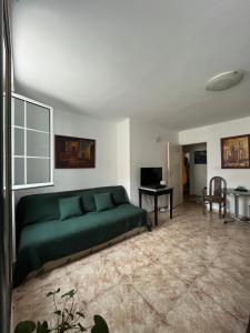 uma sala de estar com um sofá verde e uma mesa em Old Town Apartment em Herceg Novi