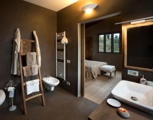 a bathroom with a tub and a sink and a bed at Coroncina in Belforte del Chienti +27 photos