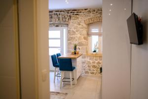 cocina con mesa y sillas azules en una habitación en Apartmani Boras en Metković