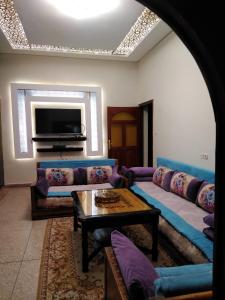 a living room with a couch and a tv at Villa Eden in Ouarzazate