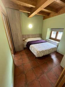 een kleine slaapkamer met een bed en een raam bij El horno Albergue Manzanos in Manzanos