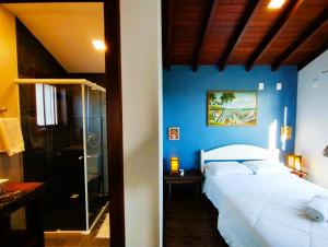 a bedroom with a white bed and a blue wall at Morada Las Palmas in Praia do Rosa +32 photos