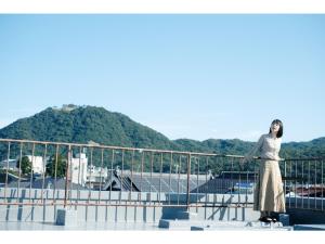 een vrouw die op een reling staat bij Tottori Guest House Miraie BASE - Vacation STAY 41214v in Tottori