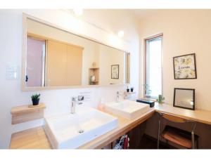 baño con 2 lavabos y espejo grande en Tottori Guest House Miraie BASE - Vacation STAY 41214v en Tottori