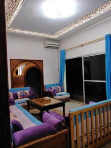 a living room with purple couches and a table at Villa Eden in Ouarzazate