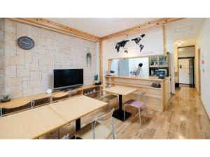 a room with two tables and a flat screen tv at Tottori Guest House Miraie BASE - Vacation STAY 41202v in Tottori