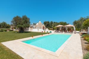 uma piscina no quintal de uma casa em Trulli Olea with Pool em San Vito dei Normanni