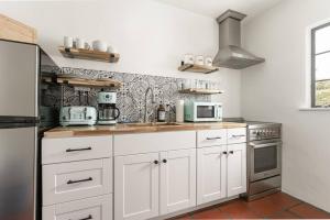 a kitchen with white cabinets and a stove at Cozy New - Casa Blanca Suite B1 in Montecito