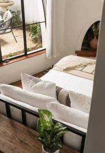 Cozy New - Casa Blanca Suite B1 في Montecito: سريرين في غرفة مع طاولة ونافذة