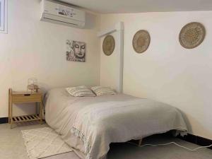 a white bedroom with a bed and a table at Villa le Yucca proche des plages catalanes in Bompas