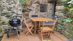 a table and chairs and a grill on a wooden deck at Gîtes chez Daniel "Cevennes 3" in Mars