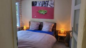 1 dormitorio con 1 cama y una pintura en la pared en Gîtes chez Daniel "Cevennes 3", en Mars
