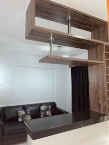 a living room with a black couch and wooden shelves at Veredas do Rio Quente Hotel Flat novo in Rio Quente