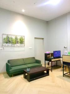 a living room with a green couch and a table at Tantra Hotel in Krui