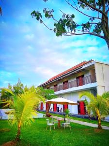 a building with tables and chairs in front of it at Tantra Hotel in Krui