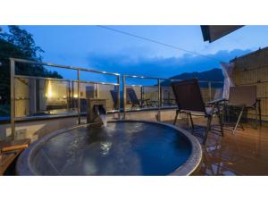 uma banheira de hidromassagem numa varanda com cadeiras e uma mesa em Hotel Sekisuien - Vacation STAY 44693v em Gujo