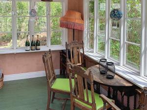 comedor con mesa, sillas y ventanas en Holiday home ÅKERSBERGA V, en Åkersberga