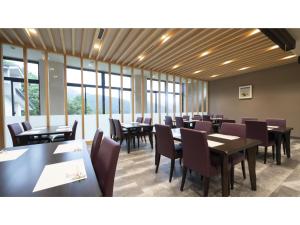 a dining room with tables and chairs and windows at Hotel Sekisuien - Vacation STAY 44700v in Gujo