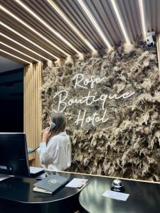 ティラナにあるRose Boutique Hotelの机の上で携帯電話を話している女性 +31枚の写真