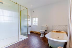 a bathroom with a bath tub and a toilet at Felicity's House with Hot Tub! 