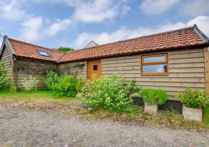 a small house with a window and some plants at Scapa Lodge in Tunstall