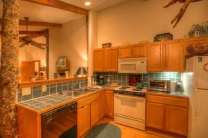 a kitchen with wooden cabinets and white appliances at Sugar Maple at Fiddlestix in Boone