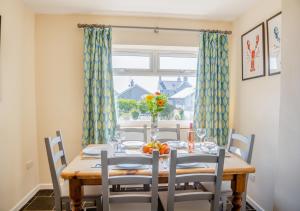 una sala da pranzo con tavolo, sedie e finestra di 3 Bro Terfyn a Morfa Nefyn