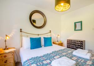 una camera da letto con un letto e uno specchio a parete di 3 Bro Terfyn a Morfa Nefyn