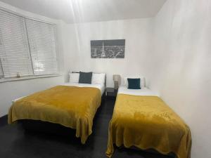 2 letti con coperte gialle in una stanza di Luxury Holiday Home a Manchester