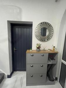 a dresser with a mirror and a blue door at Luxury Holiday Home in Manchester