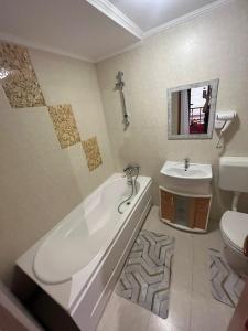 La salle de bains est pourvue d'une baignoire, d'un lavabo et de toilettes. dans l'établissement Karma caffe&rooms, à Bucarest