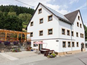 a large white building with a picnic table in front of it at Beautiful Apartment in Merschbach with Garden in Merschbach