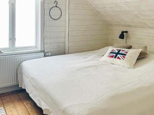 a bedroom with a large white bed with a flag pillow at Holiday home ÅSTOL 