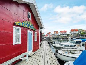 ein rotes Gebäude mit in einem Yachthafen angedockten Booten in der Unterkunft Holiday home ÅSTOL 